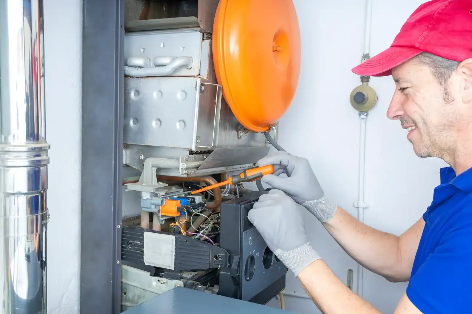 Installateur arbeitet mit Schraubendreher am geöffneten Gasgerät