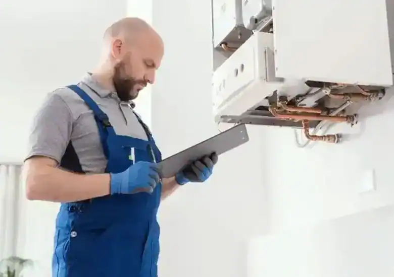 Techniker mit Tablet dokumentiert die Wartung einer Gastherme